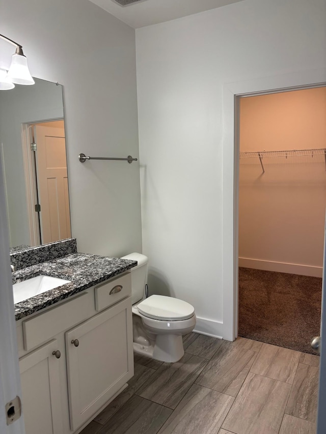 934 Governors Ct Unit 304, Antioch, TN 37013 - bathroom with wood tiled floors, toilet, vanity, and a walk in closet