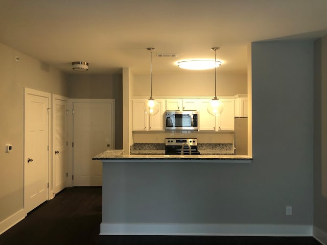 934 Governors Ct Unit 302, Antioch, TN 37013 - kitchen with stainless steel appliances, white cabinetry, hanging light fixtures, and dark stone counters