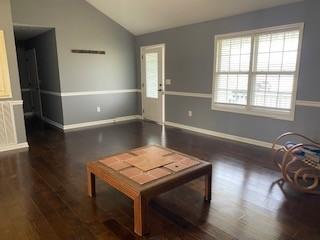117 Raspberry Dr, Winchester, TN 37398 - unfurnished living room featuring lofted ceiling, plenty of natural light, wood finished floors, and baseboards