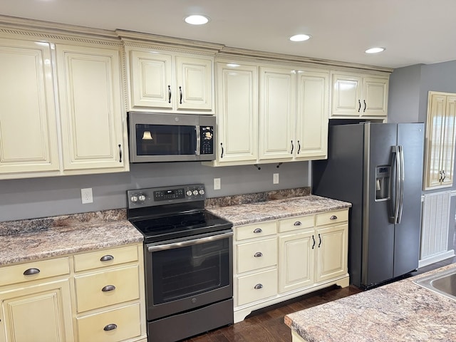 117 Raspberry Dr, Winchester, TN 37398 - kitchen with appliances with stainless steel finishes, cream cabinetry, dark wood-style floors, light countertops, and recessed lighting