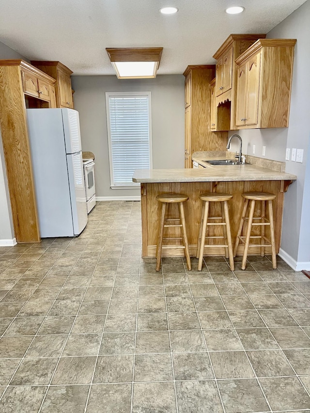 126 E Laurel Dr, Lawrenceburg, TN 38464 - kitchen with white appliances, a sink, a peninsula, light countertops, and baseboards