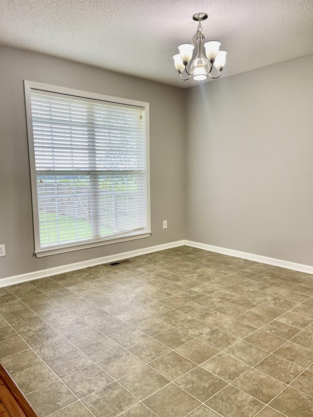 126 E Laurel Dr, Lawrenceburg, TN 38464 - spare room with a chandelier, a textured ceiling, baseboards, and dark tile patterned floors