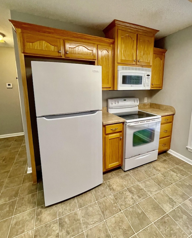 126 E Laurel Dr, Lawrenceburg, TN 38464 - kitchen featuring white appliances, light tile patterned floors, light countertops, brown cabinets, and a textured ceiling