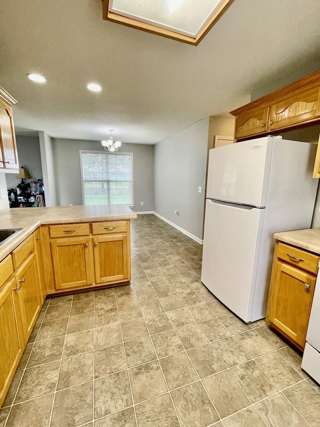 126 E Laurel Dr, Lawrenceburg, TN 38464 - kitchen featuring freestanding refrigerator, light countertops, a chandelier, recessed lighting, and a peninsula