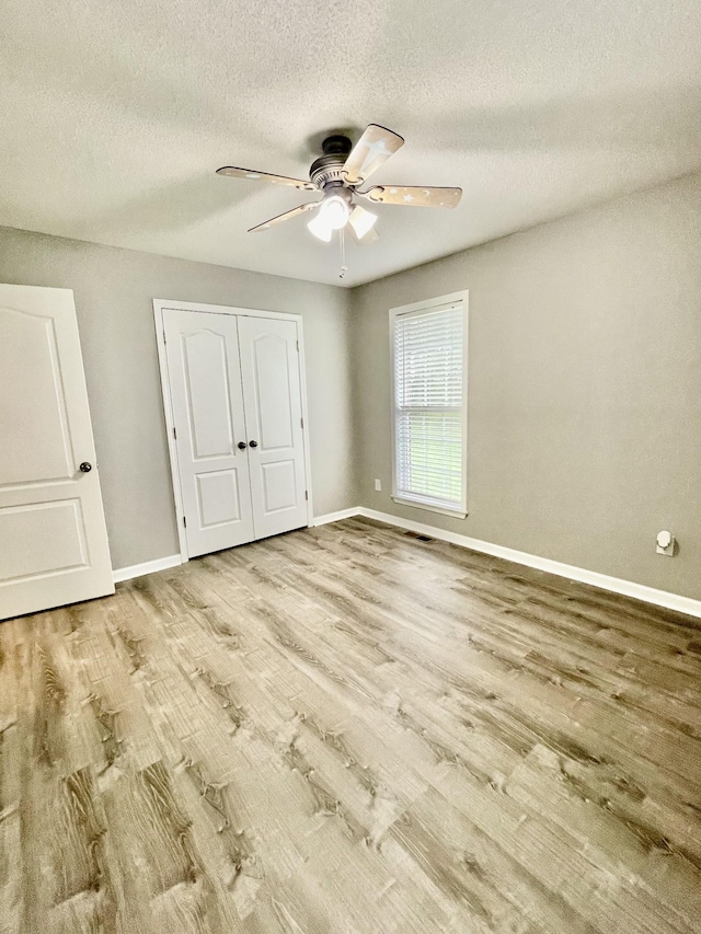 126 E Laurel Dr, Lawrenceburg, TN 38464 - unfurnished bedroom with wood finished floors, baseboards, a textured ceiling, a closet, and a ceiling fan