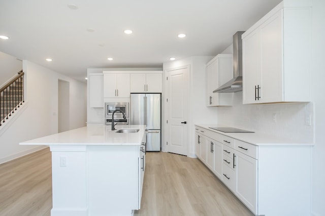 122 W Cassa Way, Mount Juliet, TN 37122 - kitchen with wall chimney range hood, stainless steel appliances, light wood-style flooring, a sink, and white cabinets