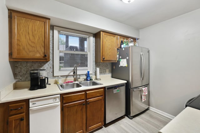 2433 Kennedy Ct Unit 2433, Franklin, TN 37064 - kitchen with appliances with stainless steel finishes, a sink, light wood-type flooring, and tasteful backsplash