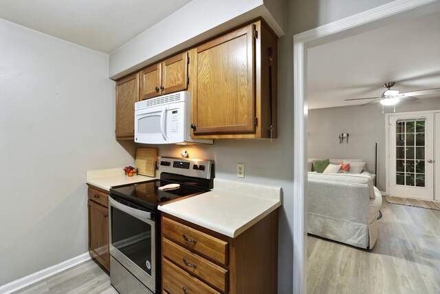 2433 Kennedy Ct Unit 2433, Franklin, TN 37064 - kitchen with stainless steel electric range oven, white microwave, light wood-style floors, brown cabinetry, and light countertops