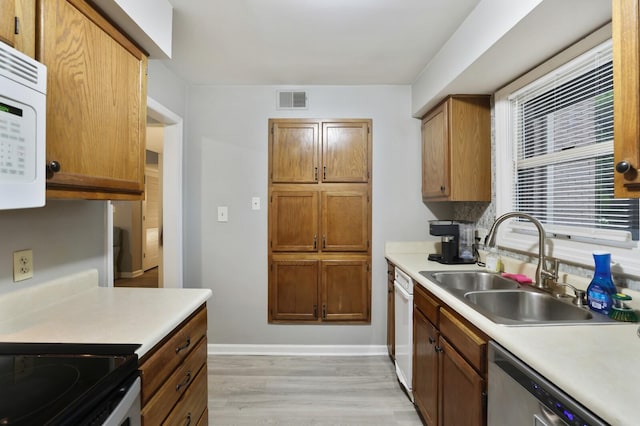 2433 Kennedy Ct Unit 2433, Franklin, TN 37064 - kitchen with dishwasher, a sink, white microwave, light countertops, and light wood-style flooring