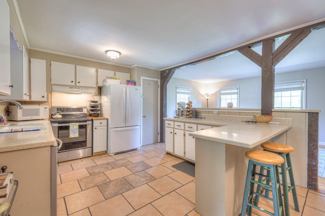 1111 Greenhill St, Murfreesboro, TN 37129 - kitchen featuring white appliances, under cabinet range hood, light countertops, a breakfast bar, and white cabinets