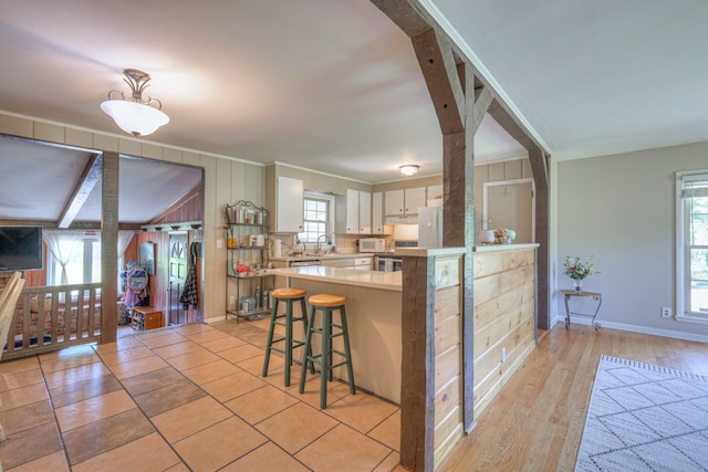 1111 Greenhill St, Murfreesboro, TN 37129 - kitchen with light countertops, a kitchen bar, white appliances, a peninsula, and white cabinets