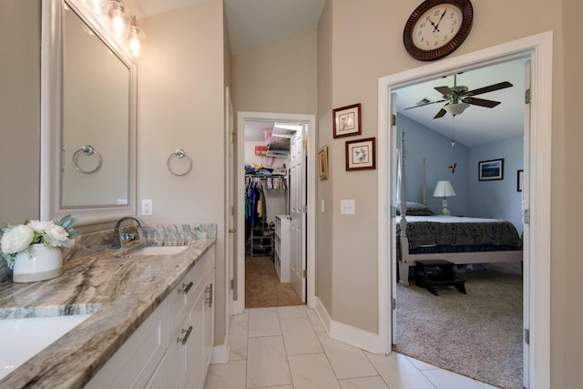 237 Dandridge Dr, Franklin, TN 37067 - ensuite bathroom with double vanity, a ceiling fan, baseboards, a walk in closet, and lofted ceiling