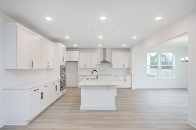 133 W Cassa Way, Mount Juliet, TN 37122 - kitchen with wall chimney range hood, appliances with stainless steel finishes, a sink, light wood-style flooring, and baseboards