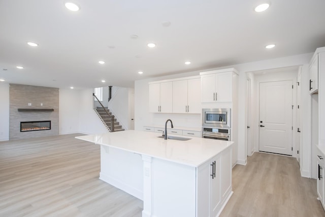 133 W Cassa Way, Mount Juliet, TN 37122 - kitchen featuring a sink, appliances with stainless steel finishes, light wood-type flooring, light countertops, and white cabinets