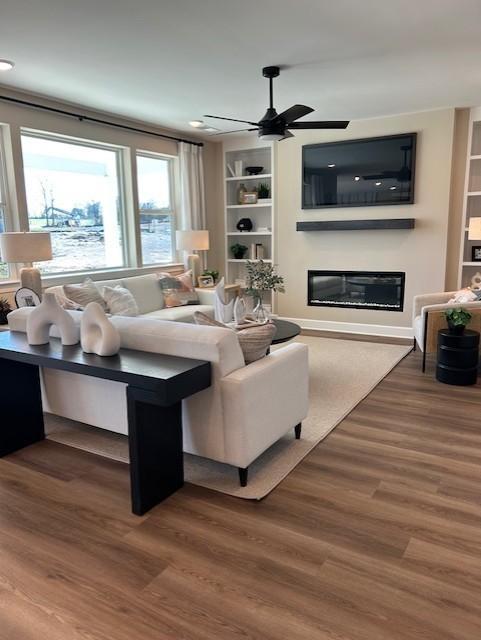 131 W Cassa Way, Mount Juliet, TN 37122 - living area with a glass covered fireplace, wood finished floors, ceiling fan, built in features, and recessed lighting