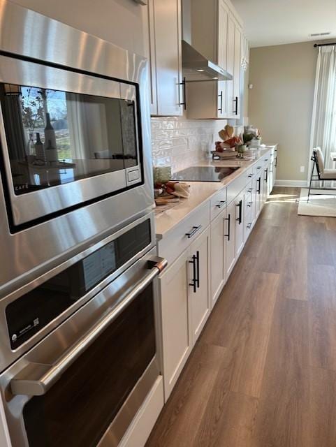 131 W Cassa Way, Mount Juliet, TN 37122 - kitchen with black electric stovetop, dark wood-style floors, light countertops, baseboards, and backsplash