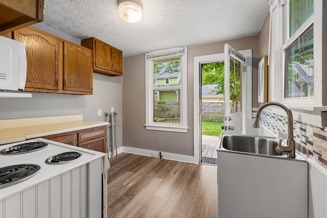 1007 Birdsall St, Old Hickory, TN 37138 - kitchen with a sink, white appliances, brown cabinetry, light countertops, and a textured ceiling