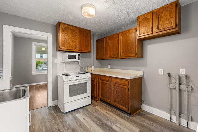 1007 Birdsall St, Old Hickory, TN 37138 - kitchen with white appliances, brown cabinets, dark wood finished floors, light countertops, and baseboards