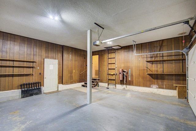 garage with wood walls and a garage door opener