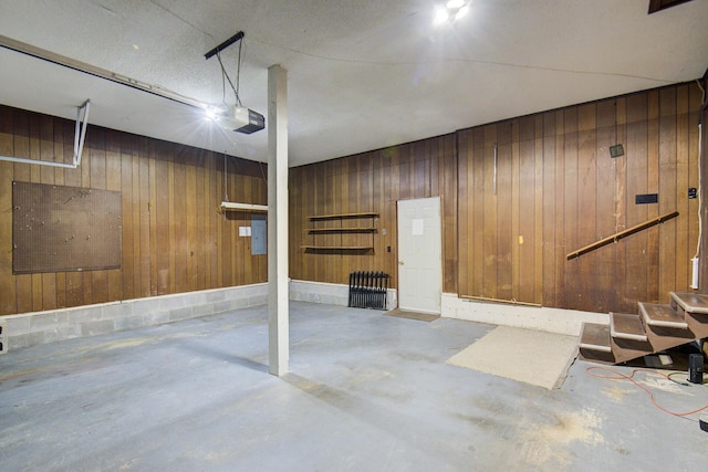 garage featuring wood walls and a garage door opener