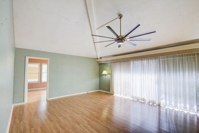 spare room featuring wood finished floors, a ceiling fan, high vaulted ceiling, and baseboards
