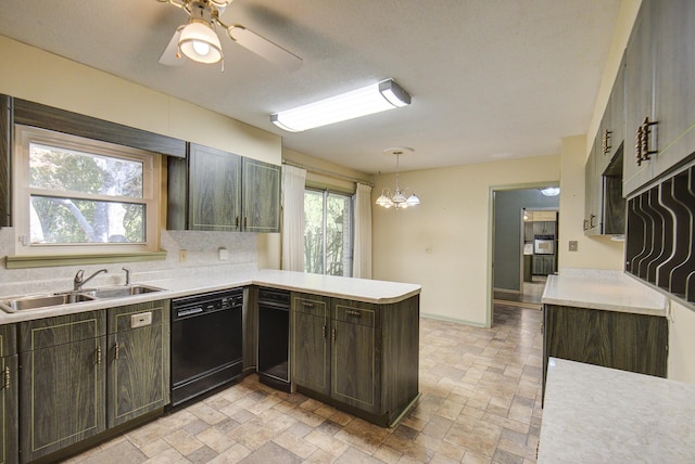 kitchen featuring dishwasher, a sink, light countertops, a peninsula, and stone tile flooring