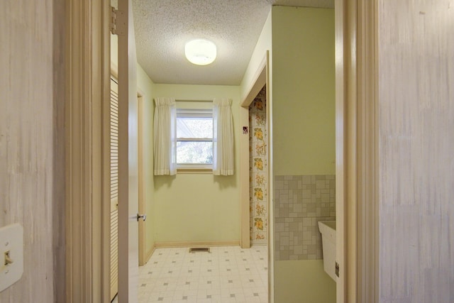 bathroom with tile patterned floors and a textured ceiling