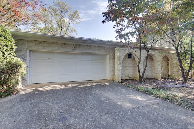 garage featuring concrete driveway