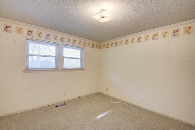 unfurnished room featuring light colored carpet, a textured ceiling, and ornamental molding