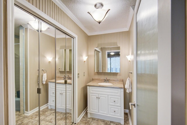 full bath with ornamental molding, vanity, tile patterned flooring, and a textured ceiling