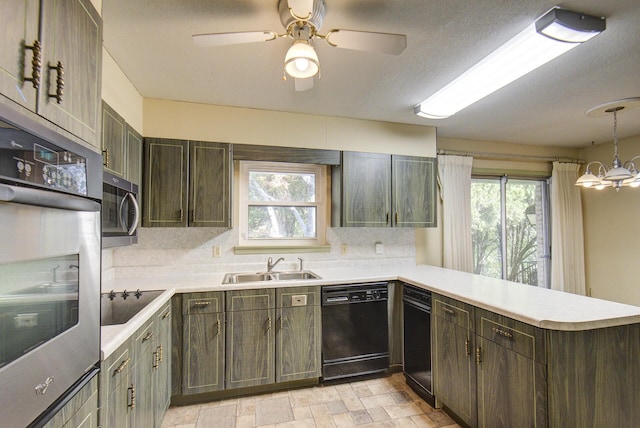 kitchen with black appliances, a sink, a peninsula, light countertops, and decorative backsplash