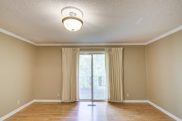 unfurnished room featuring a textured ceiling, wood finished floors, ornamental molding, and baseboards