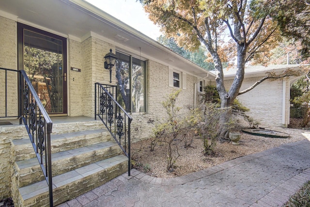 doorway to property featuring brick siding