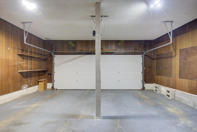 garage featuring wooden walls and a garage door opener