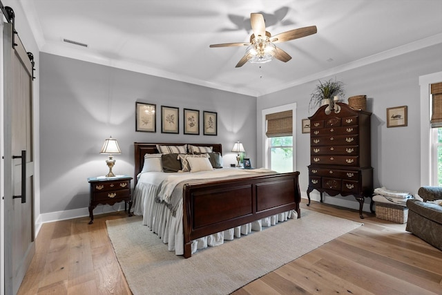 1440 Bowman Rd, Hixson, TN 37343 - bedroom with a barn door, light wood-style flooring, baseboards, ornamental molding, and ceiling fan