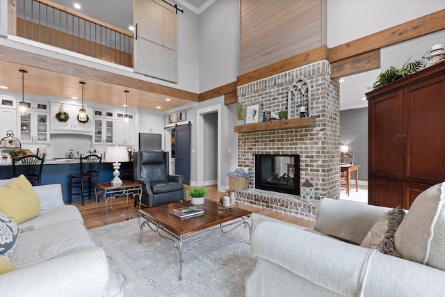 1440 Bowman Rd, Hixson, TN 37343 - living area with a barn door, a towering ceiling, light wood-style floors, a brick fireplace, and recessed lighting