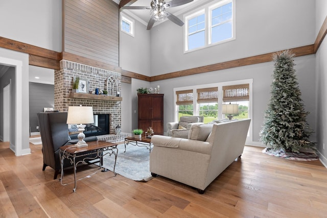 1440 Bowman Rd, Hixson, TN 37343 - living area featuring a high ceiling, light wood-type flooring, a ceiling fan, and a brick fireplace