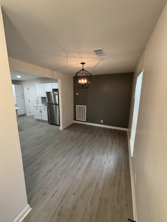 3221 New Towne Rd, Antioch, TN 37013 - unfurnished living room with wood finished floors, a chandelier, and baseboards