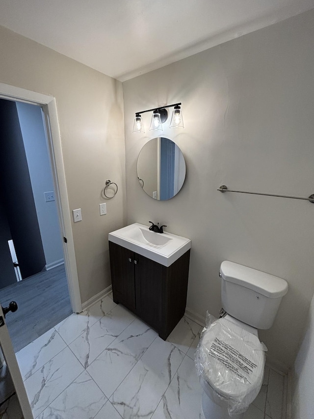 3221 New Towne Rd, Antioch, TN 37013 - bathroom with vanity, marble look tiles, toilet, and baseboards