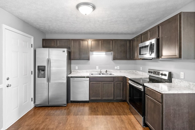 919 Linda Dr, Oak Grove, KY 42262 - kitchen featuring stainless steel appliances, wood finished floors, a sink, light countertops, and a textured ceiling