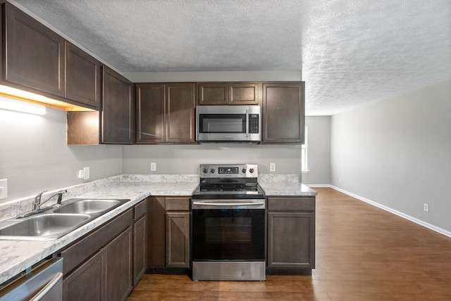 919 Linda Dr, Oak Grove, KY 42262 - kitchen featuring appliances with stainless steel finishes, a sink, a textured ceiling, dark wood finished floors, and light countertops