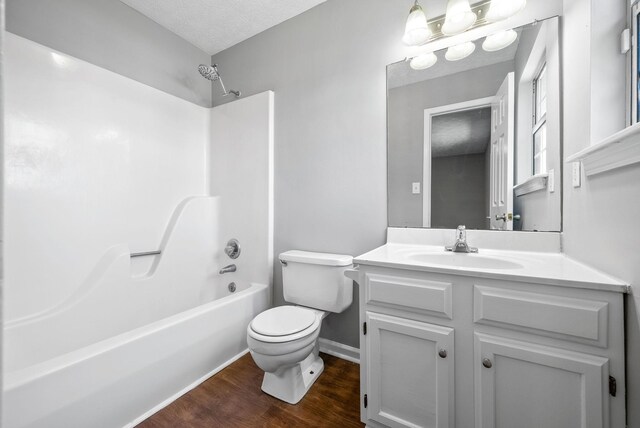919 Linda Dr, Oak Grove, KY 42262 - bathroom featuring toilet, wood finished floors, vanity, washtub / shower combination, and baseboards