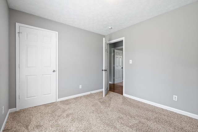 919 Linda Dr, Oak Grove, KY 42262 - unfurnished bedroom with carpet flooring, baseboards, and a textured ceiling