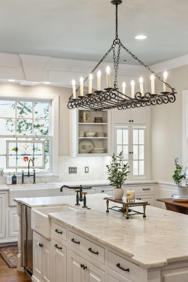901 Fair St, Franklin, TN 37064 - kitchen featuring white cabinets, light stone counters, a sink, hanging light fixtures, and decorative backsplash