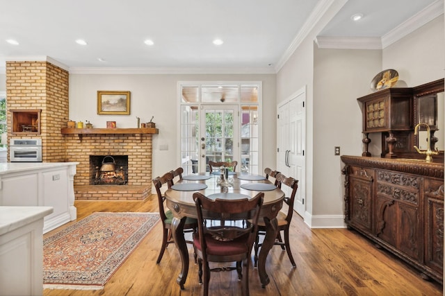 901 Fair St, Franklin, TN 37064 - dining room featuring a fireplace, light wood-style flooring, crown molding, baseboards, and recessed lighting