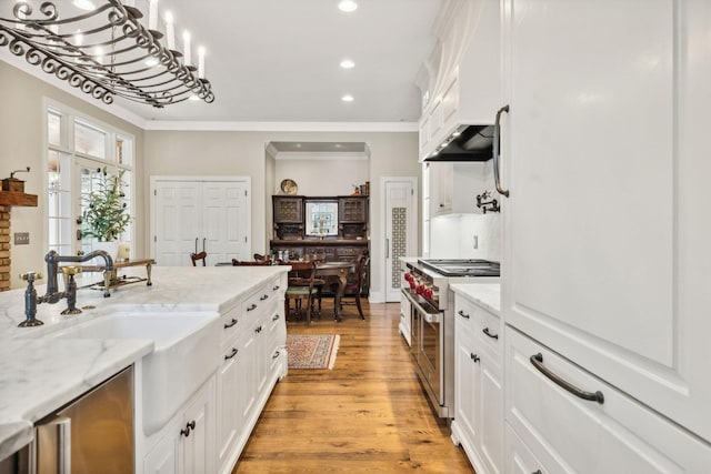 901 Fair St, Franklin, TN 37064 - kitchen featuring stainless steel range, white cabinets, ornamental molding, recessed lighting, and light wood finished floors