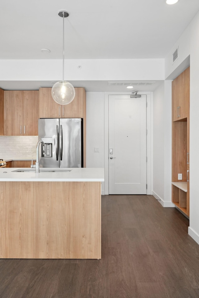1212 Demonbreun St Unit A13 J, Nashville, TN 37203 - kitchen with stainless steel refrigerator with ice dispenser, light countertops, dark wood-style floors, pendant lighting, and decorative backsplash