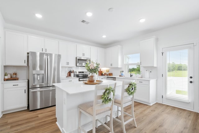 108 Model Ct, Columbia, TN 38401 - kitchen with stainless steel appliances, white cabinets, light countertops, a kitchen island, and tasteful backsplash