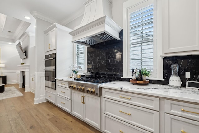 2143 White Poplar Ct, Murfreesboro, TN 37130 - kitchen with premium range hood, ornamental molding, light wood finished floors, decorative backsplash, and light stone counters