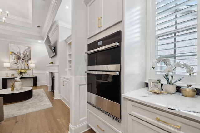 2143 White Poplar Ct, Murfreesboro, TN 37130 - kitchen with double oven, light wood-type flooring, light stone counters, crown molding, and white cabinets